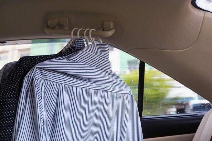 Banyak kemeja tergantung di mobil.