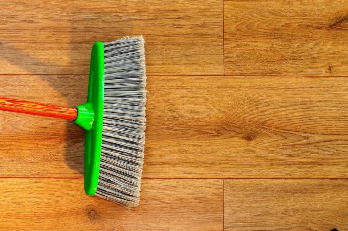membersihkan lantai kayu dengan sapu