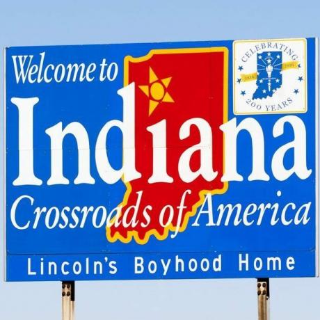 Il segno blu contro il cielo blu ti dà il benvenuto in Indiana