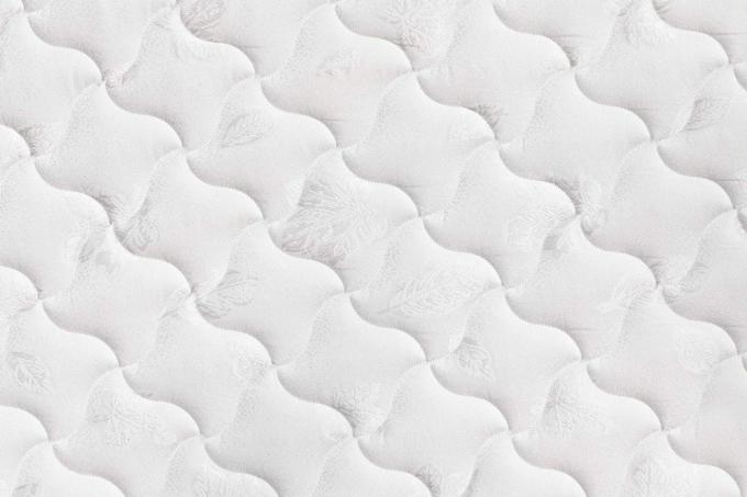 A puha, kényelmes steppelt fehér matrac háttere
