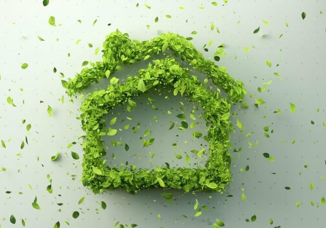 Imagen generada digitalmente del icono de la casa hecho de hojas sobre fondo verde blanco.