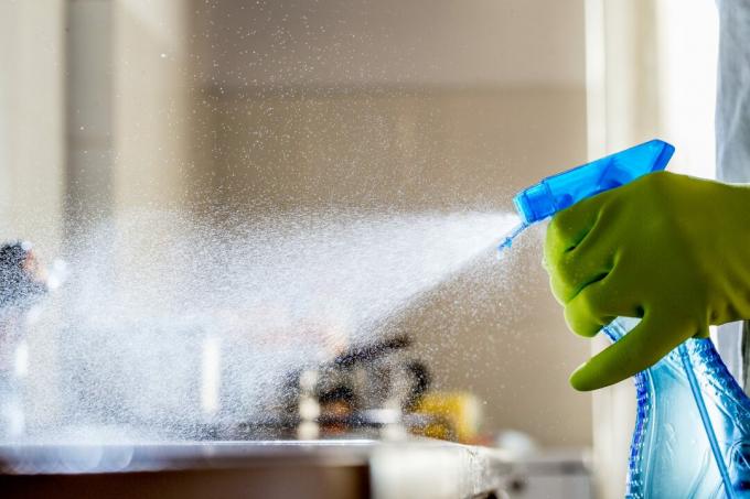 Pulverización de producto de limpieza en la encimera de la cocina