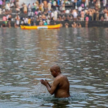 Индуистские преданные выполняют ритуал тарпан во время молитвы Махалая, также известной как Питру Пакша, в резервуаре с водой Банганга в Мумбаи, Индия.
