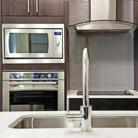 Modernus prabangus virtuvės interjeras su akmeniniu stalviršiu ir nerūdijančio plieno prietaisais