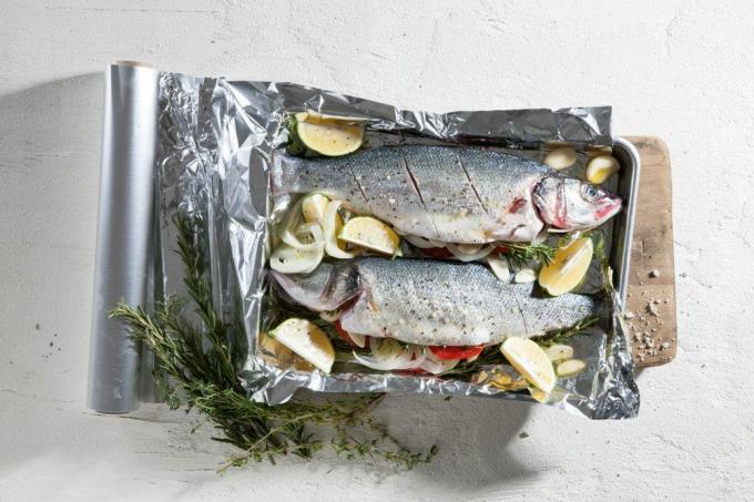 En hel fisk i ovnen- en tradisjonell rett. Hver ingrediens i dette kurset er naturlig og frisk. Mat skutt ovenfra.