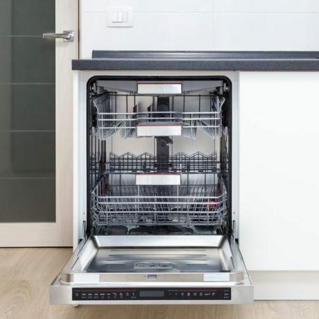 Innebygd oppvaskmaskin med åpen dør på et hvitt kjøkken