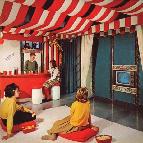 Børn ser fjernsyn i et rum med cirkustema i 1960'erne