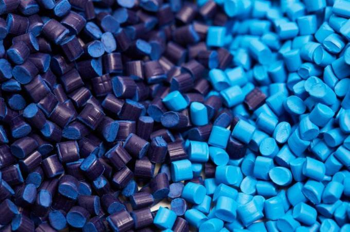 Zblízka dvoch stohov modrých plastových polypropylénových granúl na stole