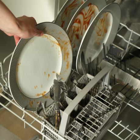 汚れた皿を食器洗い機に入れる