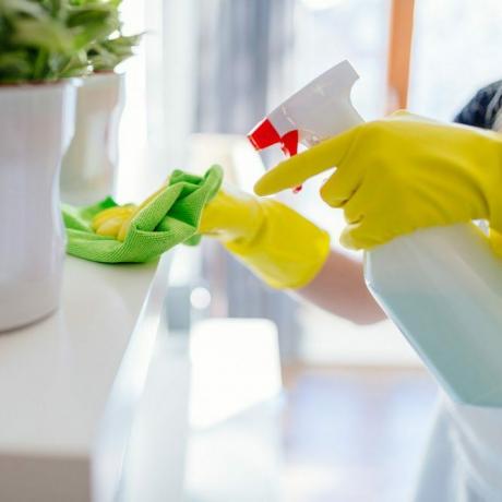Kvinne iført gule gummihanskende hansker og rengjøring av hvit hylle.; Shutterstock ID 546648748; Jobb (TFH, TOH, RD, BNB, CWM, CM): TOH DIY All Purpose Cleaner
