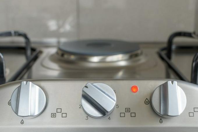 botão do fogão elétrico na bancada da cozinha com luz de operação acesa