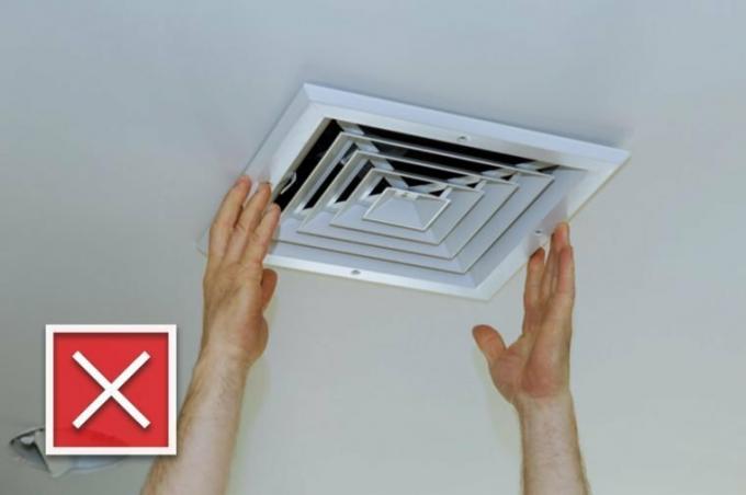 Cierre la mano del hombre instalando la cubierta de ventilación del aire acondicionado montado en el techo.