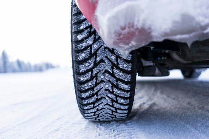 सर्दियों के मौसम में बर्फ से ढके टायर का क्लोज अप