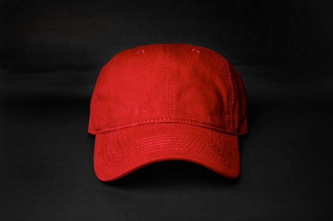 Gorra de algodón rojo sobre un fondo negro, vista de fuente.