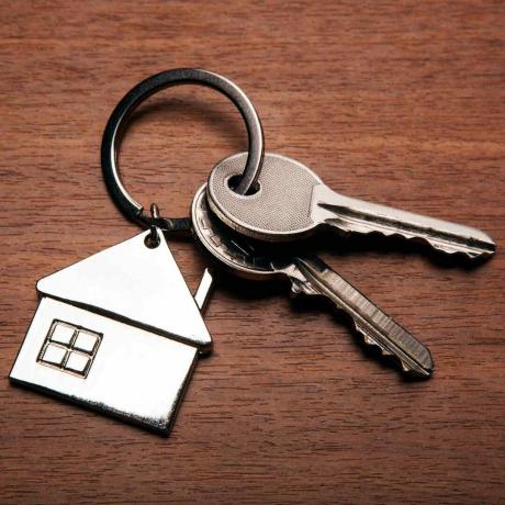 nycklar-från-lägenheten-med-en-nyckelring-i-form-av-ett-hus-närbild