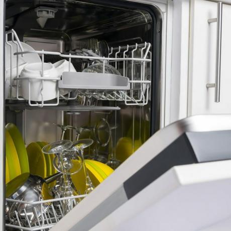 porta da máquina de lavar louça aberta com pratos limpos dentro