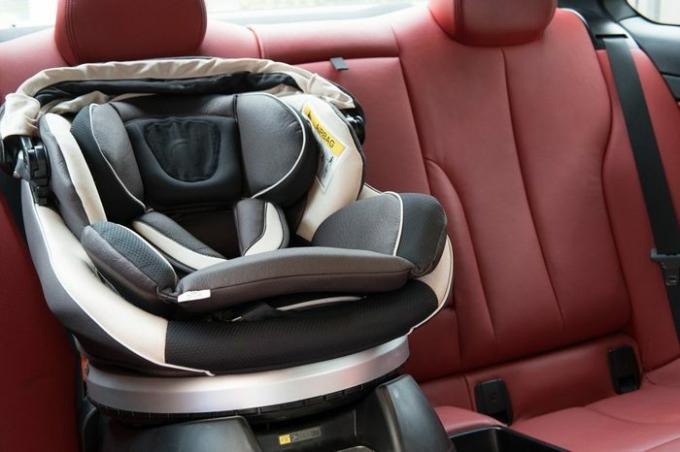 Colocación de asiento de coche en coche deportivo de lujo. concepto de seguridad para bebés.