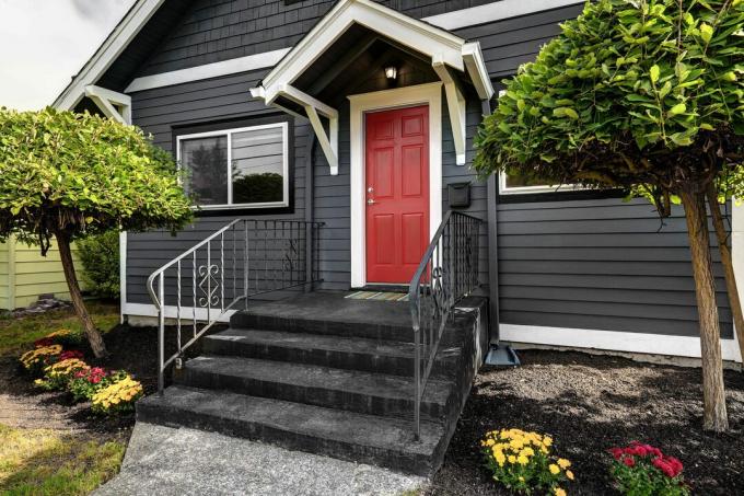dunkelschwarzes Haus außen mit einer roten Tür