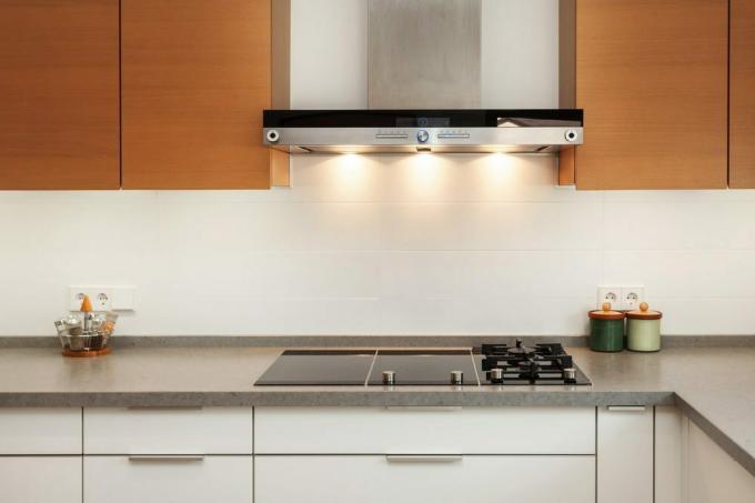 ภาพระยะใกล้ของท่อดูดควันและจานทำอาหารเซรามิกในห้องครัวสมัยใหม่ใหม่