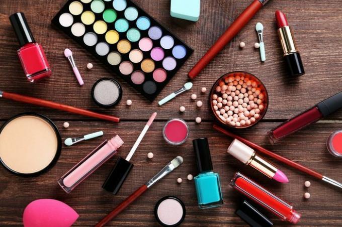 Différents produits cosmétiques de maquillage sur une table en bois marron