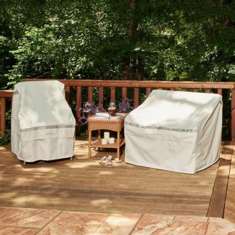 twee stoelen op een houten dek bedekt met de hoezen voor het opbergen van meubels