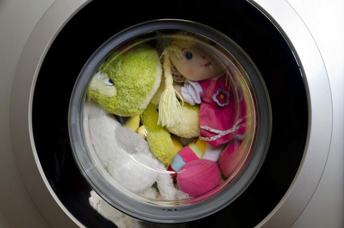 Vrata pralnega stroja z vrtljivimi igračami v notranjosti