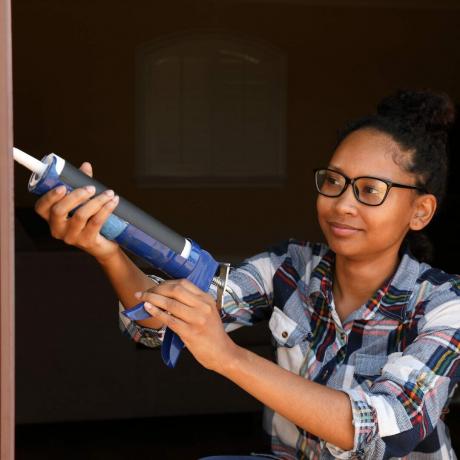 Kartuschenpistole afroamerikanische Frau Brille horizontal