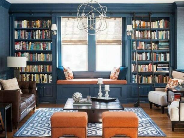 bibliotecă mare albastră cu scaun la fereastră