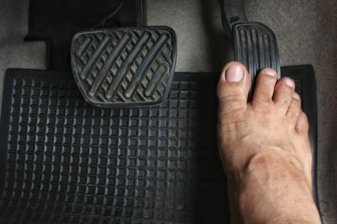 Tutup kaki telanjang pengemudi di pedal di dalam mobil, Konsep keselamatan untuk mengemudi.