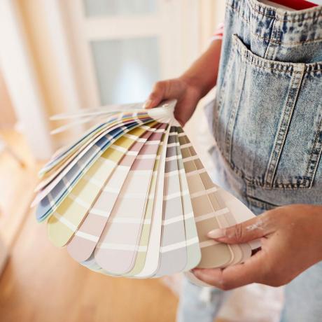 Mujer eligiendo el color de la pintura durante la renovación del hogar