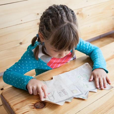 Gadis kecil melihat peta harta karun.